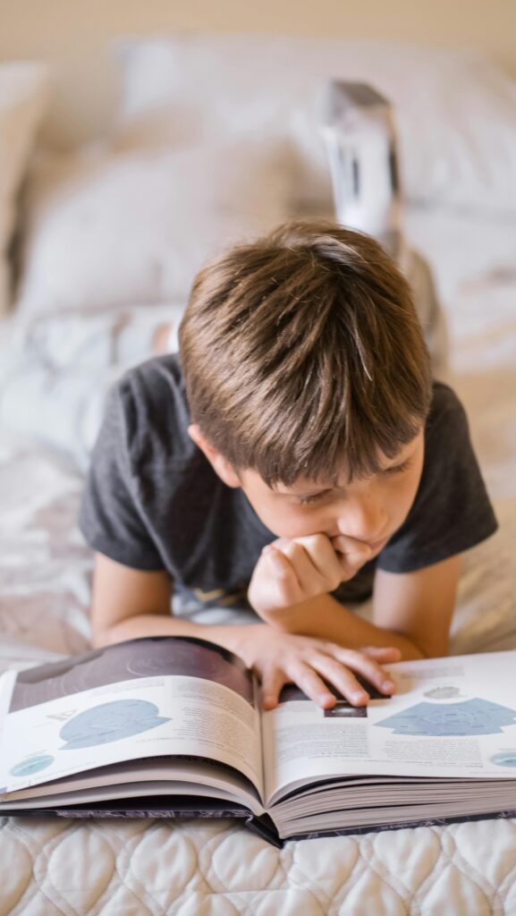 Boy reading a book with focused attention