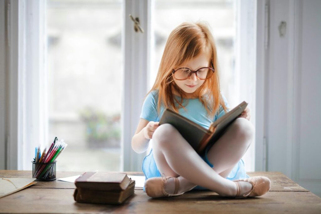 Young student reading independently by a window